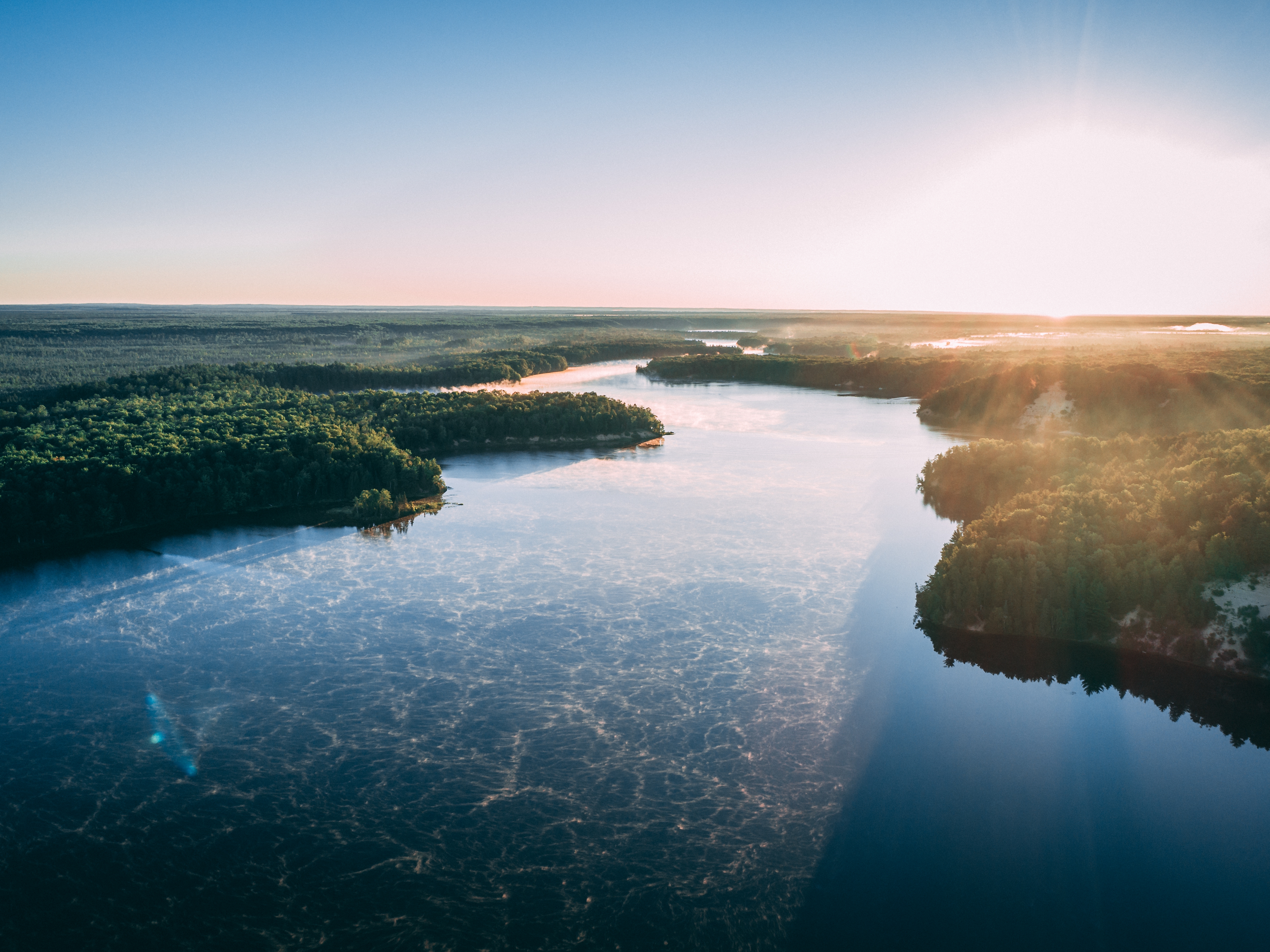 aerial picture river surrounded by islands covered greenery sunlight