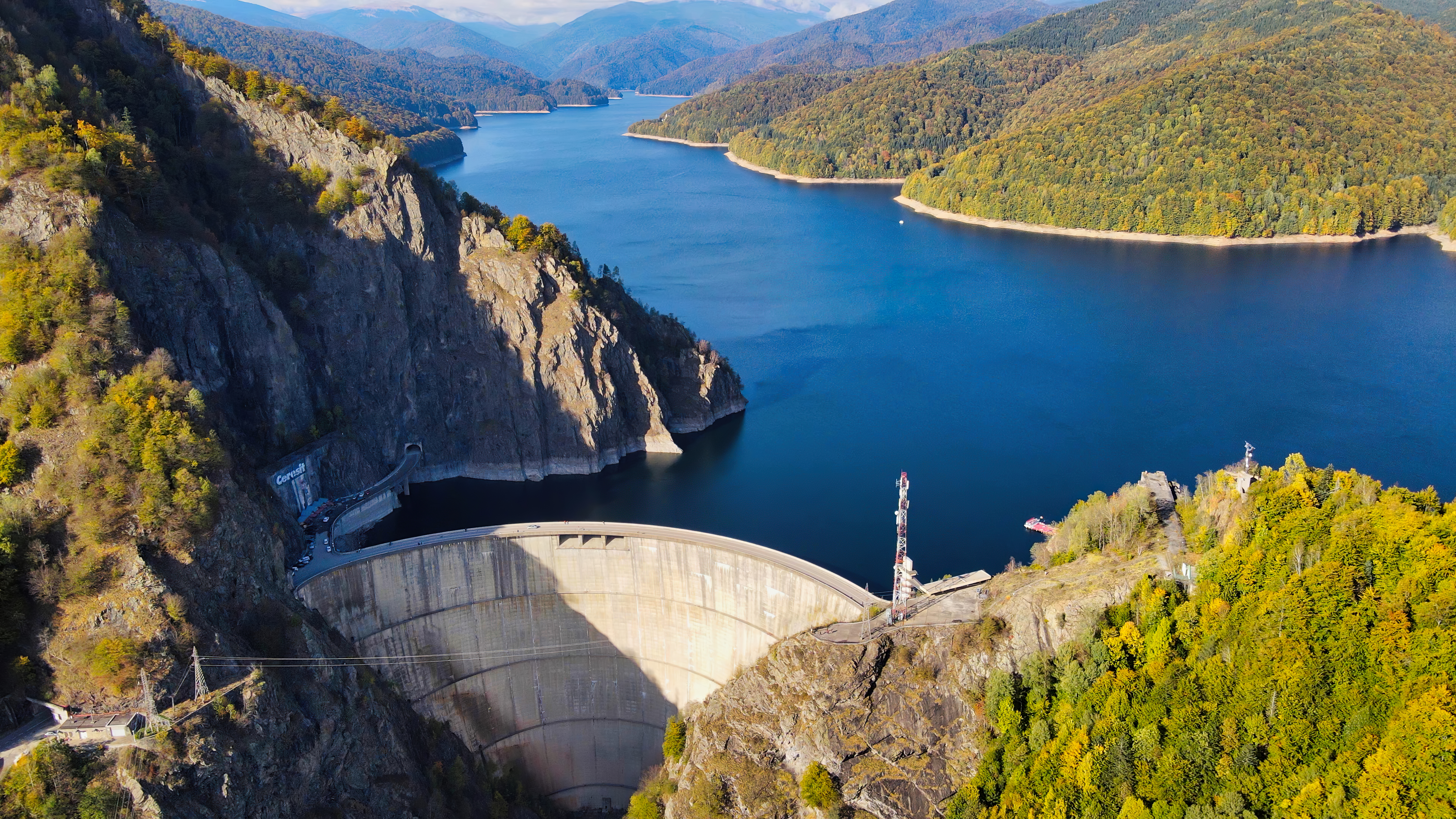 Aerial drone view of nature in Romania. Valley in Carpathian mountains with Vidraru dam and lake, slopes with lush forest